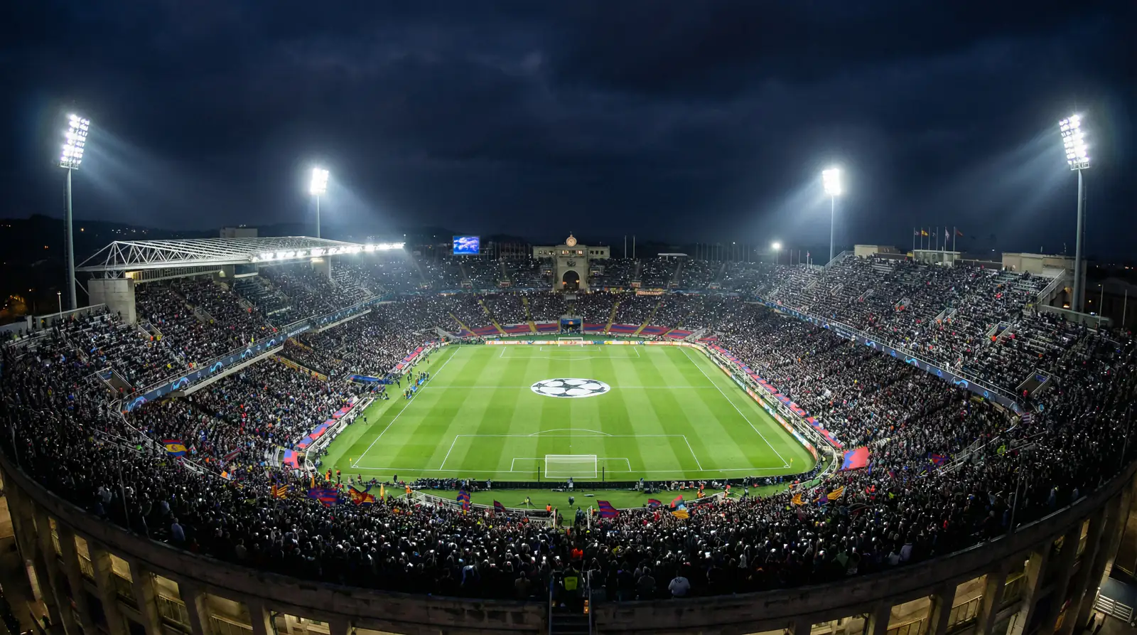 Europees voetbalstadion bij avond met felle verlichting en een stervormig patroon op het veld
